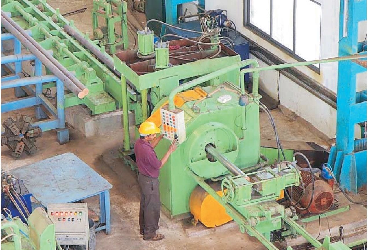 A man standing next to machinery in an industrial setting.