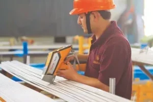 A man in an orange hard hat is using a sander.