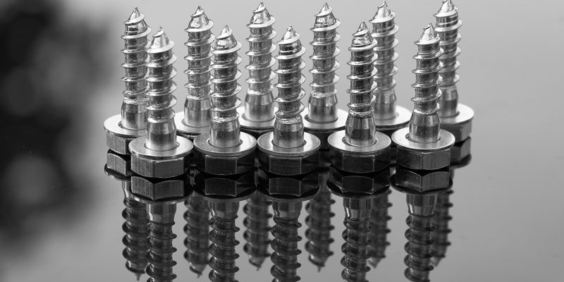 A group of metal nuts and bolts on top of a table.