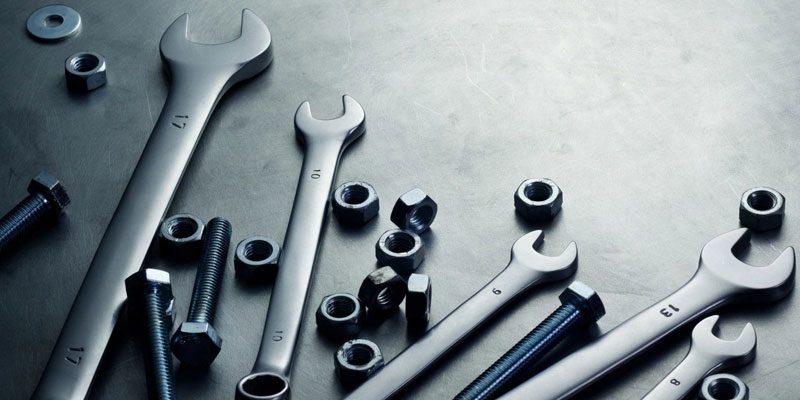 A group of wrenches and other tools on top of a table.