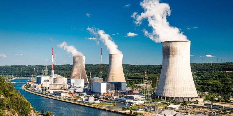 A large power plant with three cooling towers.